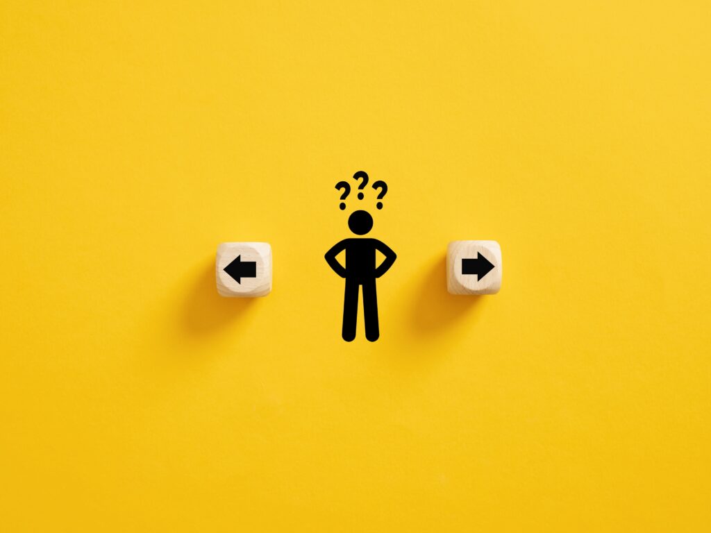 A stick figure with wooden arrow blocks going opposite directions on either side and question marks above his head.